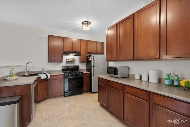 239 Nicole Dr Unit A, South Elgin, IL 60177 - kitchen featuring gas stove, freestanding refrigerator, a sink, light countertops, and under cabinet range hood