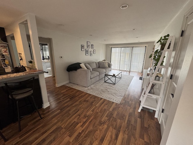 living area with dark wood-style floors, baseboards, and recessed lighting