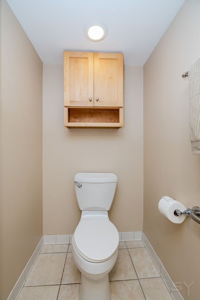 bathroom with baseboards, tile patterned flooring, and toilet