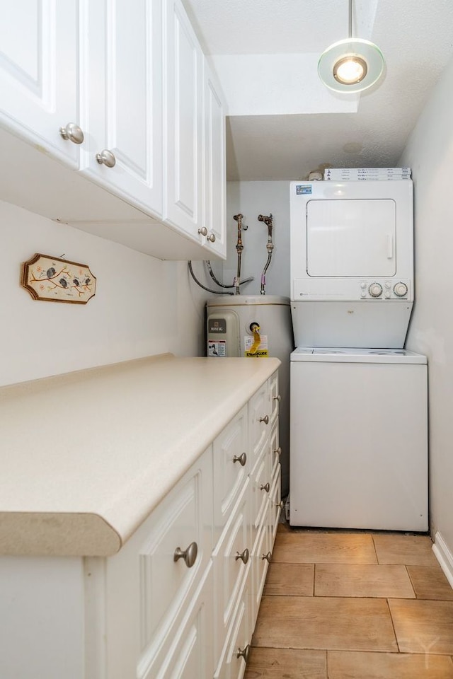 laundry room featuring stacked washer / drying machine, light wood-type flooring, and cabinet space