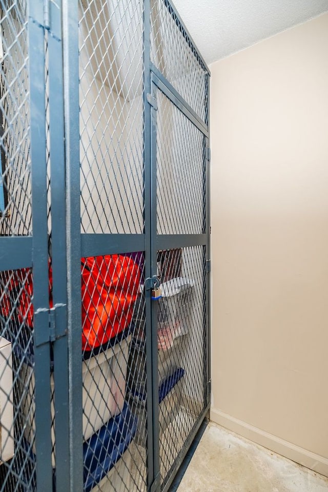 detailed view of baseboards, unfinished concrete floors, and a gate
