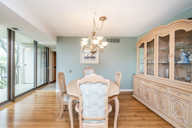 dining room featuring a chandelier, baseboards, and light wood-style flooring