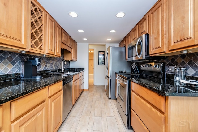 kitchen with stainless steel appliances, a sink, recessed lighting, decorative backsplash, and baseboards