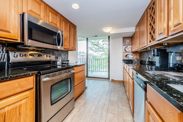 kitchen with stainless steel appliances, tasteful backsplash, baseboards, dark stone countertops, and recessed lighting