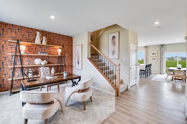 dining space featuring light wood-type flooring, baseboards, stairs, recessed lighting, and an accent wall