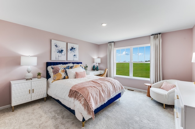 bedroom with light carpet and baseboards