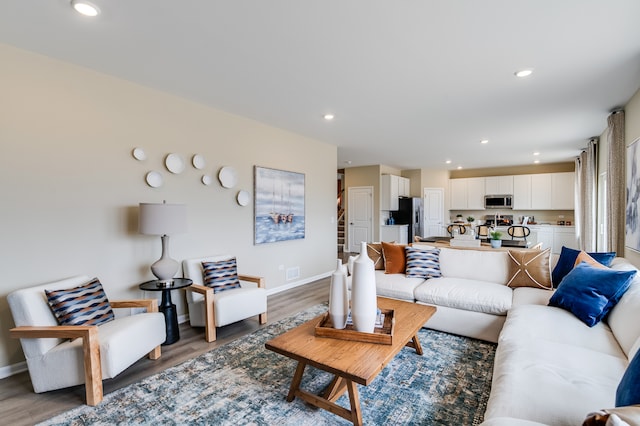 living area with light wood-style flooring, baseboards, and recessed lighting