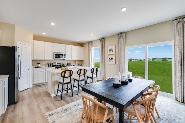 dining space with light wood-style floors and recessed lighting