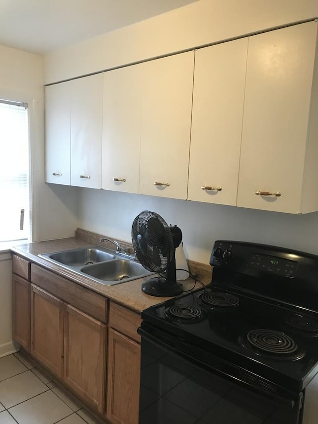 802 Bellwood Ave Unit 2S, Bellwood, IL 60104 - kitchen featuring black electric range, a sink, light tile patterned flooring, and brown cabinets