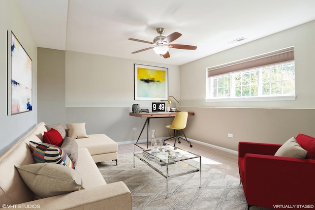 carpeted living room featuring ceiling fan and baseboards