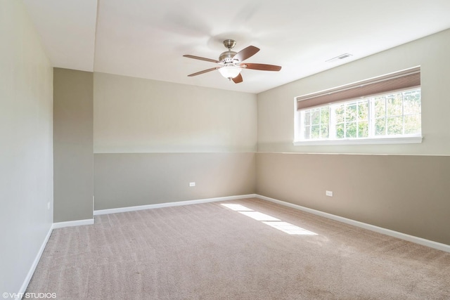spare room with a ceiling fan, carpet floors, and baseboards