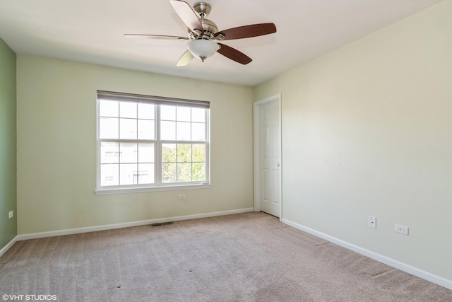 spare room featuring carpet floors, a ceiling fan, and baseboards