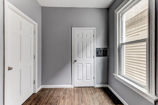 907 W 50th St, Chicago, IL 60609 - unfurnished bedroom with dark wood-style floors, multiple windows, and baseboards