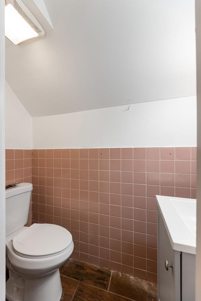907 W 50th St, Chicago, IL 60609 - half bathroom with tile walls, toilet, vanity, a wainscoted wall, and lofted ceiling