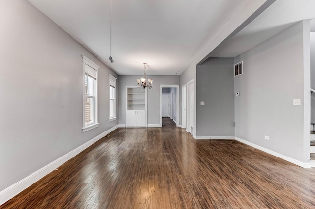 907 W 50th St, Chicago, IL 60609 - unfurnished living room featuring a chandelier, baseboards, and dark wood-style floors