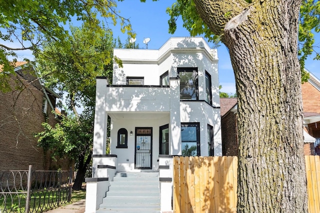 4336 W Gladys Ave, Chicago, IL 60624 - view of front facade with stucco siding, a balcony, and a porch