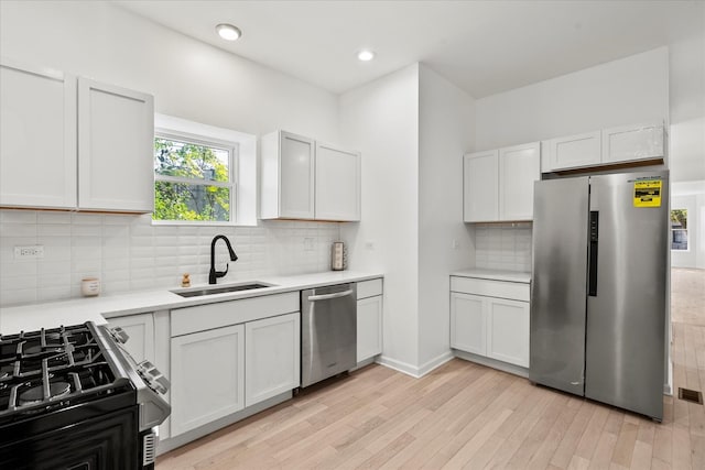 4336 W Gladys Ave, Chicago, IL 60624 - kitchen featuring appliances with stainless steel finishes, a sink, light countertops, light wood-style flooring, and tasteful backsplash