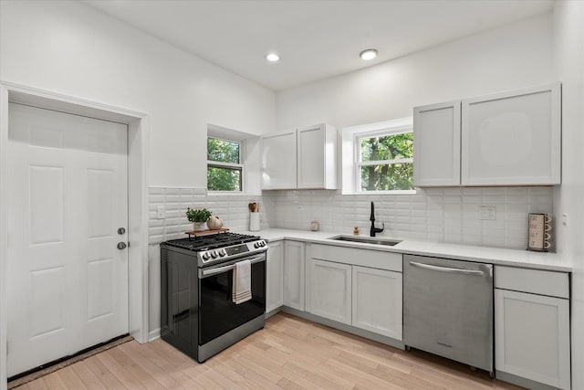 4336 W Gladys Ave, Chicago, IL 60624 - kitchen featuring appliances with stainless steel finishes, a sink, healthy amount of natural light, light countertops, and recessed lighting
