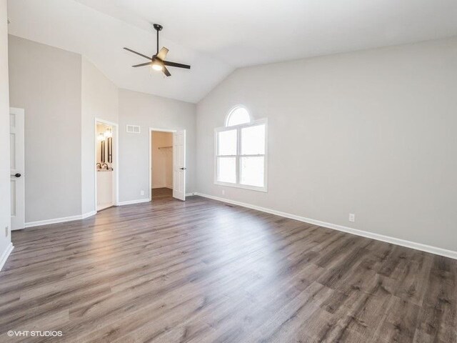35491 N Kenneth Dr, Lake Villa, IL 60046 - unfurnished bedroom featuring a walk in closet, baseboards, dark wood-type flooring, high vaulted ceiling, and ceiling fan