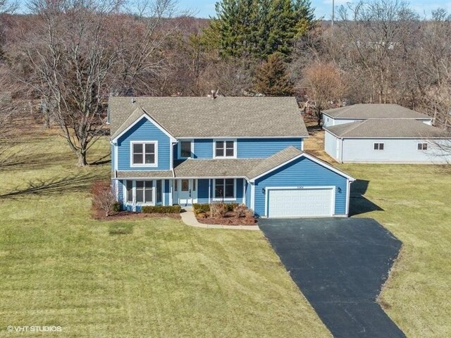 35491 N Kenneth Dr, Lake Villa, IL 60046 - traditional-style home with driveway, an attached garage, a front lawn, and roof with shingles