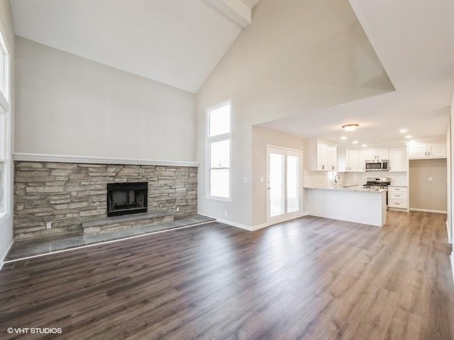 35491 N Kenneth Dr, Lake Villa, IL 60046 - unfurnished living room with high vaulted ceiling, a fireplace, wood finished floors, a sink, and baseboards