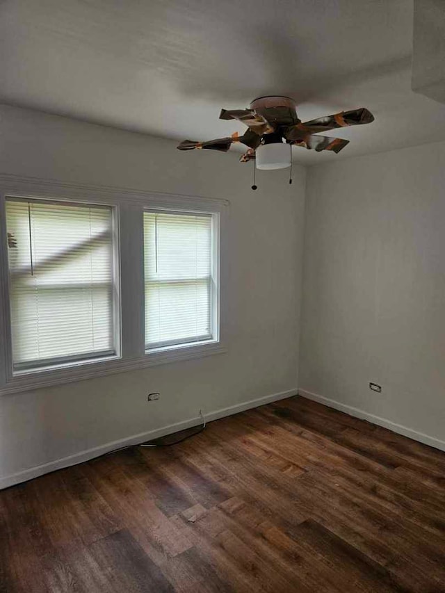 unfurnished room featuring wood finished floors, baseboards, and a ceiling fan