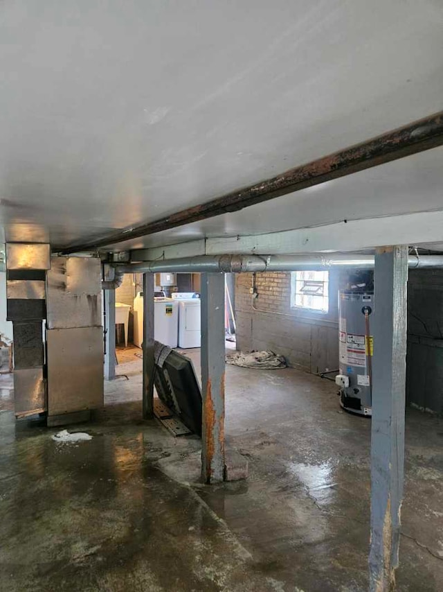basement featuring gas water heater, washing machine and clothes dryer, and heating unit
