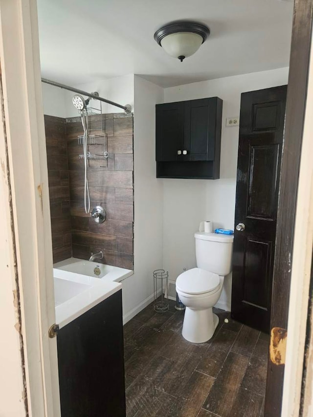 full bathroom featuring wood finished floors, toilet, and baseboards
