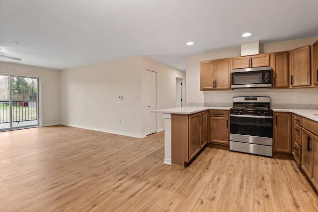 2034 W 75th Pl Unit 35, Merrillville, IN 46410 - kitchen featuring appliances with stainless steel finishes, a peninsula, light countertops, light wood-type flooring, and recessed lighting