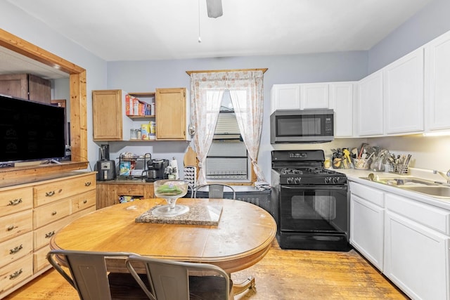 2814 W 40th St, Chicago, IL 60632 - kitchen featuring stainless steel microwave, black gas range, light wood-style floors, white cabinets, and ceiling fan
