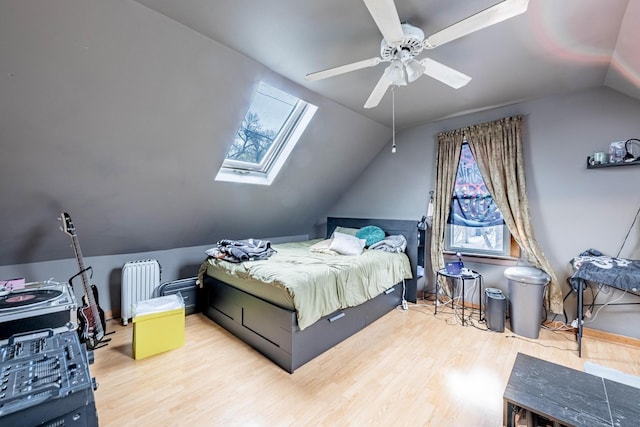 2814 W 40th St, Chicago, IL 60632 - bedroom featuring radiator, vaulted ceiling, wood finished floors, a skylight, and a ceiling fan