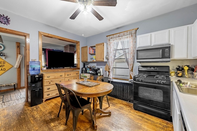 2814 W 40th St, Chicago, IL 60632 - kitchen featuring stainless steel microwave, black range with gas cooktop, a ceiling fan, light wood-style flooring, and white cabinets