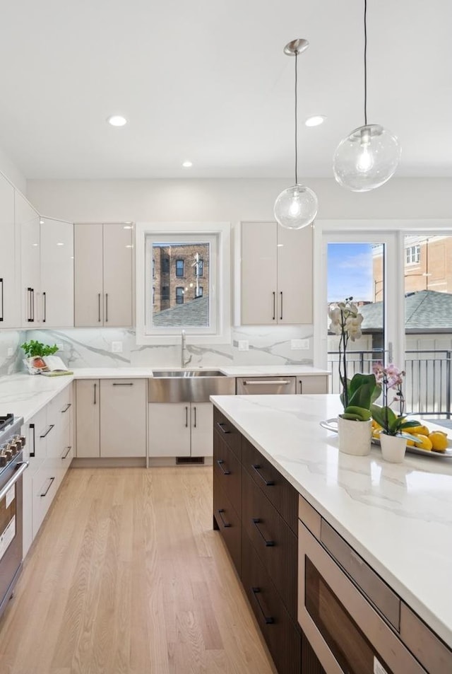965 E 62nd St Unit 1, Chicago, IL 60637 - kitchen with appliances with stainless steel finishes, modern cabinets, decorative backsplash, light wood-type flooring, and a sink