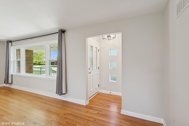 6502 Palma Ln, Morton Grove, IL 60053 - unfurnished room featuring a chandelier, light wood-style floors, and baseboards