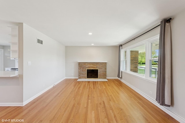 6502 Palma Ln, Morton Grove, IL 60053 - unfurnished living room featuring light wood-style floors, a stone fireplace, baseboards, and recessed lighting