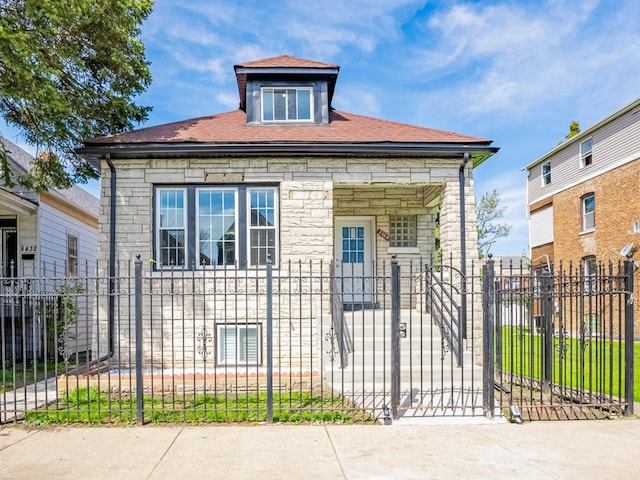 8430 S Manistee Ave, Chicago, IL 60617 - view of front facade with stone siding, a fenced front yard, a shingled roof, and a gate