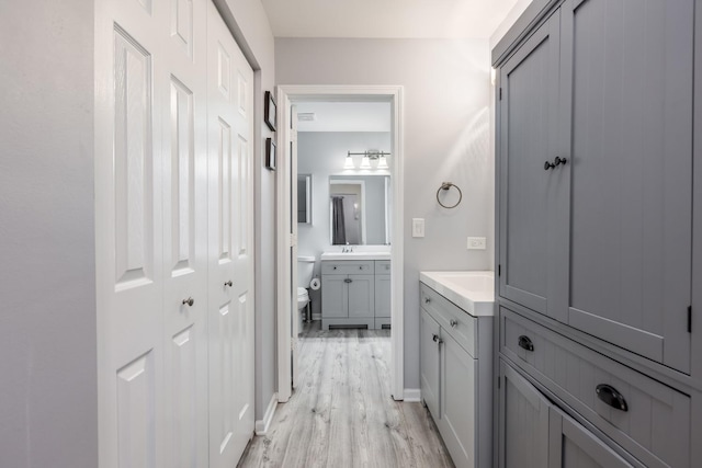 1357 Coldspring Rd, Carol Stream, IL 60188 - full bathroom with two vanities, wood finished floors, toilet, and a closet