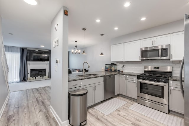 1357 Coldspring Rd, Carol Stream, IL 60188 - kitchen with stainless steel appliances, a sink, dark stone countertops, light wood-style floors, and decorative backsplash