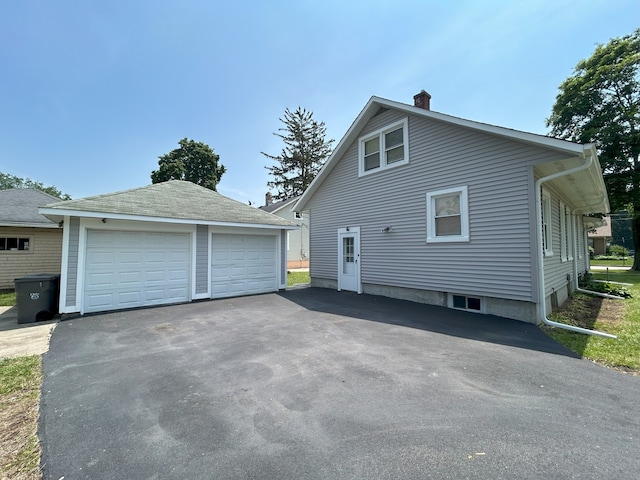 650 Enterprise St, Elgin, IL 60120 - view of home's exterior with a chimney, a garage, and an outbuilding