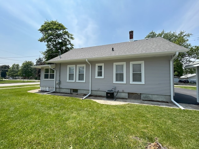 650 Enterprise St, Elgin, IL 60120 - back of property featuring a lawn, a chimney, cooling unit, and a shingled roof