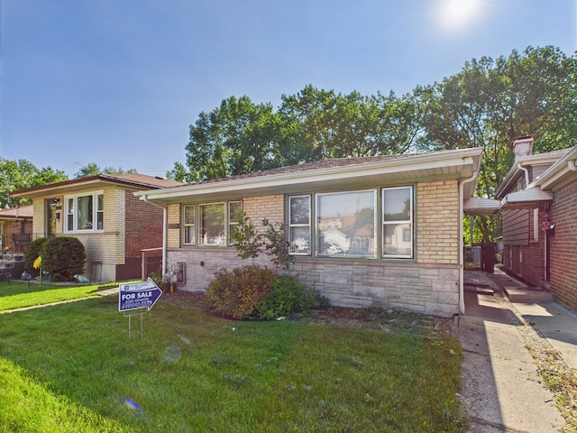 11314 S Green Bay Ave, Chicago, IL 60617 - view of front of property featuring a front yard, stone siding, and brick siding