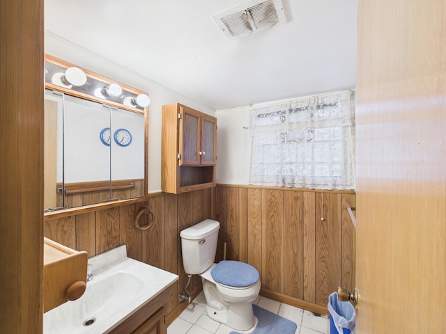 11314 S Green Bay Ave, Chicago, IL 60617 - half bath featuring toilet, vanity, wainscoting, wooden walls, and tile patterned floors