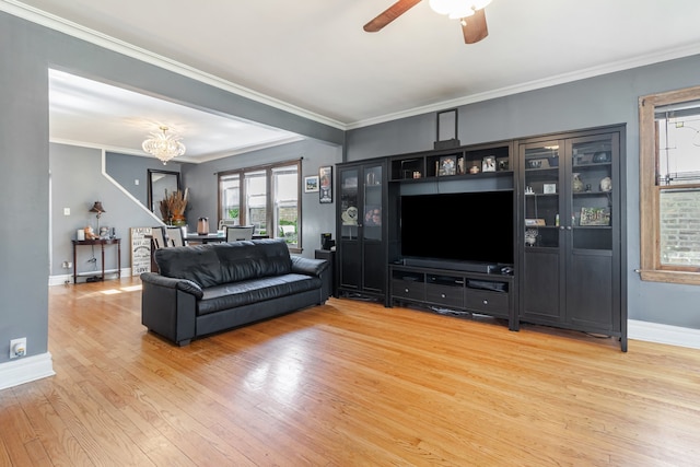 5945 W Dakin St, Chicago, IL 60634 - living room with light wood finished floors, baseboards, ceiling fan, a chandelier, and ornamental molding