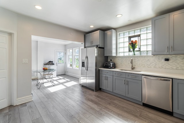 5945 W Dakin St, Chicago, IL 60634 - kitchen featuring appliances with stainless steel finishes, gray cabinets, a sink, light wood-style floors, and recessed lighting