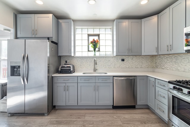 5945 W Dakin St, Chicago, IL 60634 - kitchen featuring appliances with stainless steel finishes, a sink, gray cabinetry, recessed lighting, and light wood finished floors