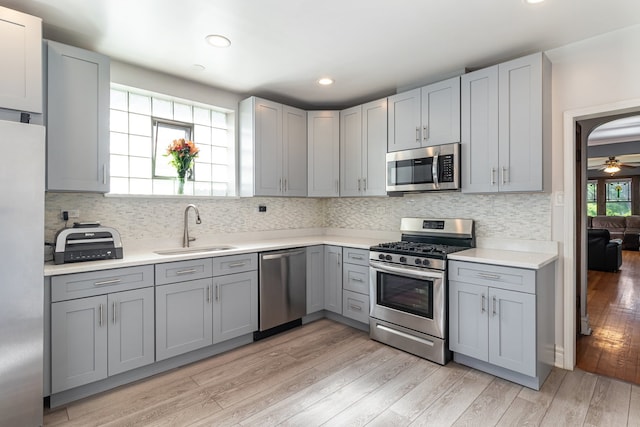 5945 W Dakin St, Chicago, IL 60634 - kitchen featuring appliances with stainless steel finishes, a sink, gray cabinetry, light wood-type flooring, and light countertops