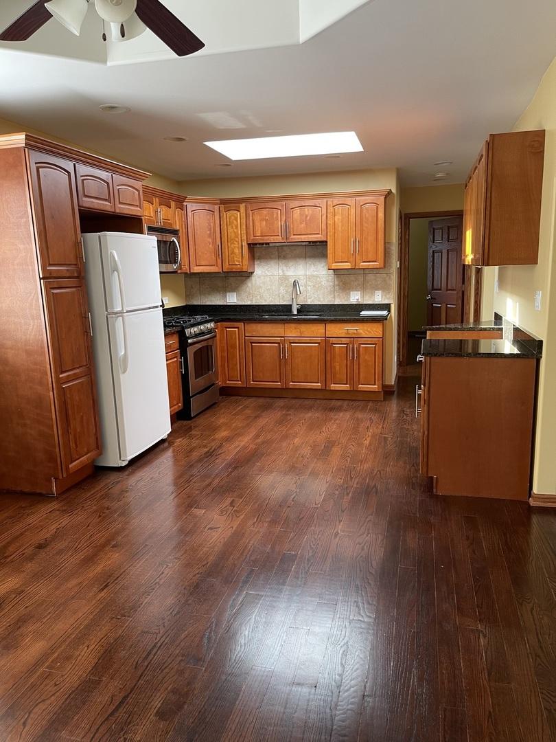 7927 Lotus Ave, Burbank, IL 60459 - kitchen featuring stainless steel appliances, dark wood-type flooring, dark countertops, and ceiling fan