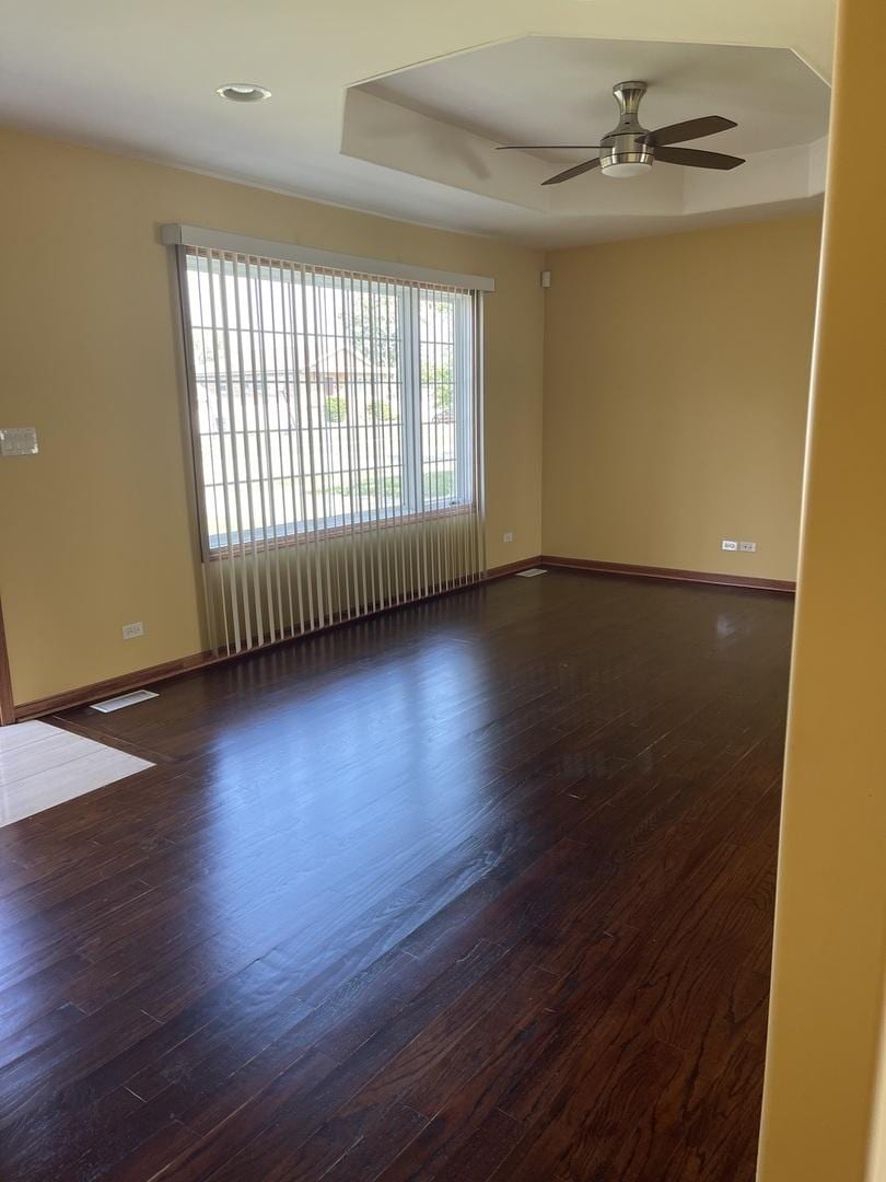 7927 Lotus Ave, Burbank, IL 60459 - empty room featuring dark wood-style flooring, a ceiling fan, and baseboards