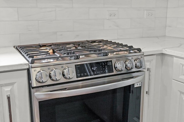 3412 Sunnyside Ave, Brookfield, IL 60513 - detailed view of stainless steel gas range, backsplash, light stone counters, and white cabinets