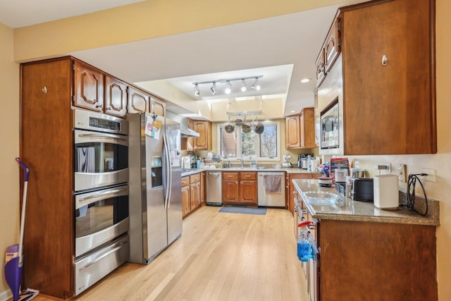 51 Oak Creek Dr, Burr Ridge, IL 60527 - kitchen featuring stainless steel appliances, a warming drawer, light wood-style flooring, a raised ceiling, and brown cabinets